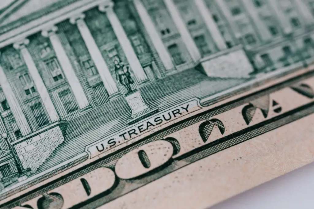 Close-up of U.S. Treasury text on a dollar bill showing detailed engraving of government building