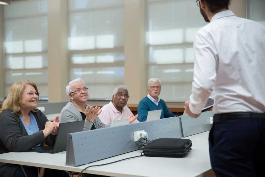 Instructor teaching a diverse group of older adults in a modern classroom setting